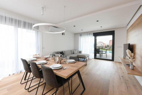 a dining table and chairs in a living room at FUX LUXURY Infinty-Pool Zadar in Zadar