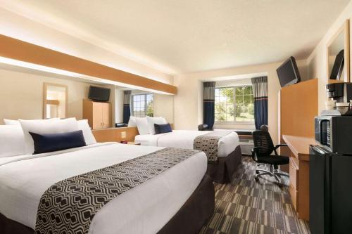 Cette chambre comprend deux lits et une télévision. dans l'établissement Microtel Inn & Suites by Wyndham Culpeper, à Culpeper