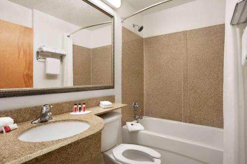 a bathroom with a sink and a toilet and a tub at Microtel Inn & Suites by Wyndham Culpeper in Culpeper