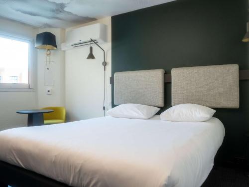 ニースにあるイビス ニース サントル ガールの緑の壁のベッドルーム1室(白いベッド1台付)