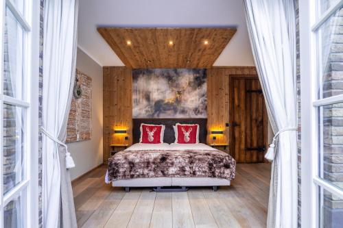 a bedroom with a bed with two red pillows at B&B Hof van Eerde in Eerde