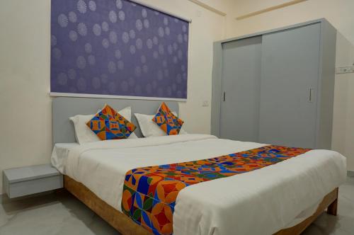 1 dormitorio con 2 camas y una gran pintura en la pared en ESTA STAY en Pune