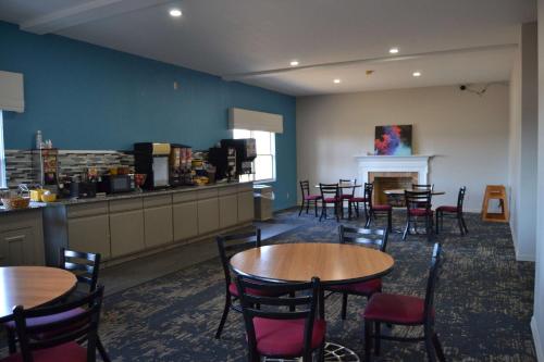 a dining room with tables and chairs and a fireplace at Days Inn and Suites by Wyndham Sikeston in Sikeston