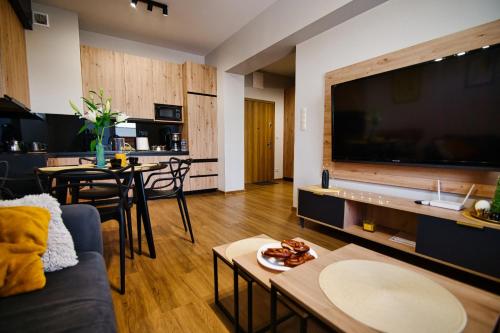 a living room with a large flat screen tv at Apartament No82 Yellow Holiday Home Zator in Zator