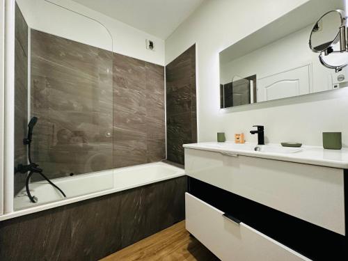 un bagno con lavandino e vasca da bagno di Home de Vitruve a Amboise