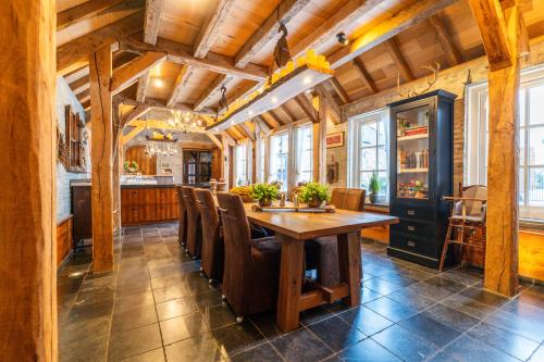 een eetkamer met een houten tafel en stoelen bij B&B Hof van Eerde in Eerde