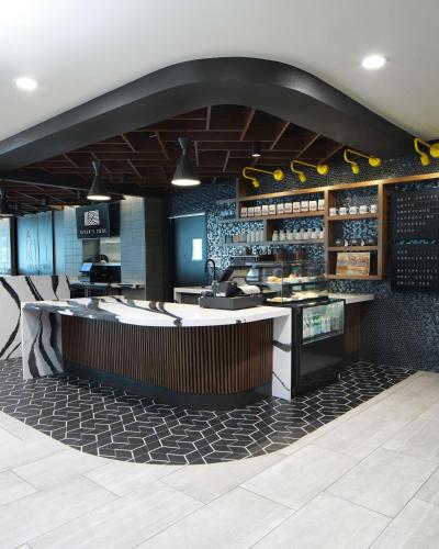 a restaurant with a counter and a bar with chairs at River's Edge Hotel Portland, Tapestry Collection by Hilton in Portland