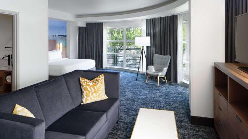 um quarto de hotel com um sofá e uma cama em River's Edge Hotel Portland, Tapestry Collection by Hilton em Portland