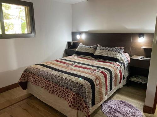 1 dormitorio con cama y ventana en Anita Haus Casa de fin de semana en Garupá