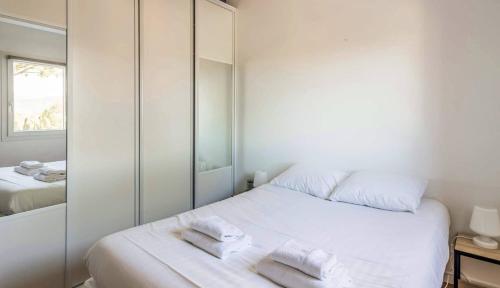 une chambre avec un lit blanc avec des serviettes dessus dans l'établissement Mazet VI - Golfe de Saint-Tropez, à Gassin