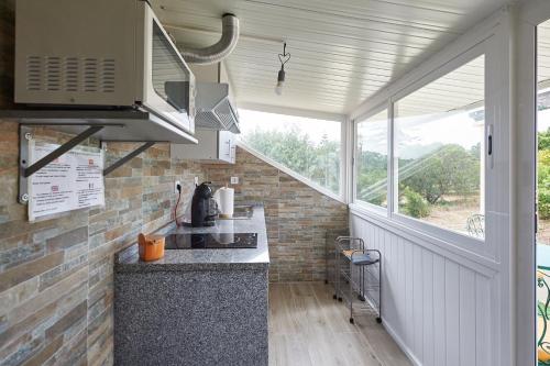 a kitchen with a counter top and a window at Sintra Breeze - Sun, Pool & Kitchen in Mem Martins