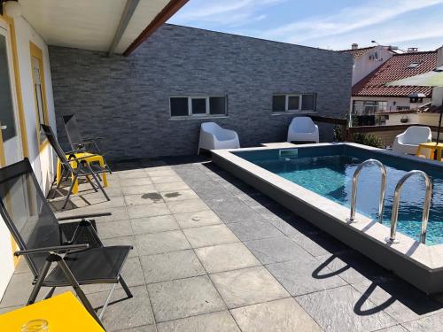 a swimming pool on a patio with chairs at Sintra Breeze - Sun, Pool & Kitchen in Mem Martins