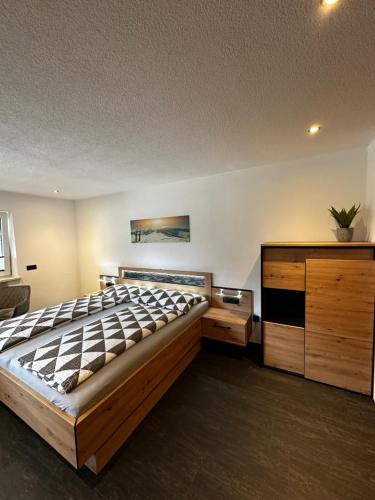 - une chambre avec un grand lit et une commode dans l'établissement Haus Brugger Richard, à Zell am Ziller