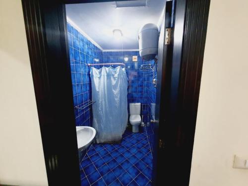 a blue tiled bathroom with a toilet and a sink at Porto Matroh New Chalets in Marsa Matruh
