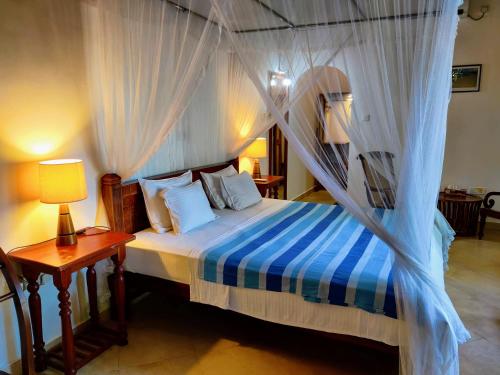 een slaapkamer met een hemelbed bij Siroma Villa in Bentota