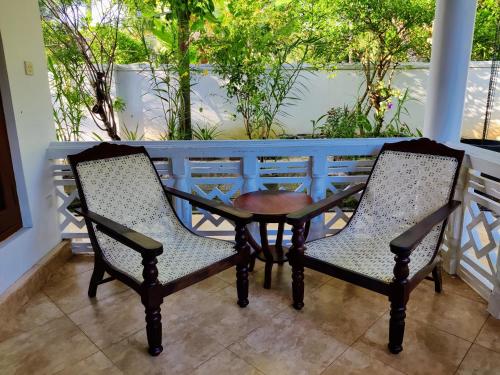 two chairs and a table on a porch at Siroma Villa in Bentota