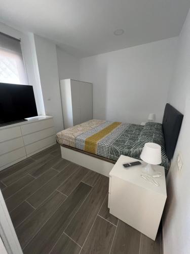 a bedroom with a bed and a table and a tv at Apartamentos Montalvo Metropolis C in Torremolinos