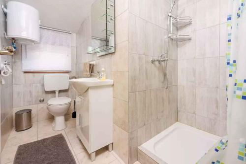 uma casa de banho com um chuveiro, um WC e um lavatório. em Apartments in Crikvenica 45899 em Crikvenica