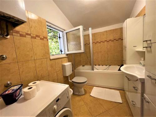 een badkamer met een toilet, een bad en een wastafel bij Apartments in Medulin - Istrien 46722 in Medulin