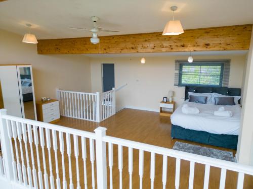 a bedroom with a large bed and a staircase at Luxury 2 Bed Apartment – Near Heathrow, Legoland, Windsor Slough in Slough