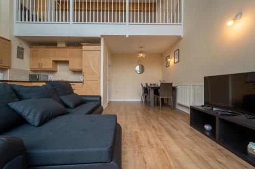 a living room with a couch and a dining room at Luxury 2 Bed Apartment – Near Heathrow, Legoland, Windsor Slough in Slough