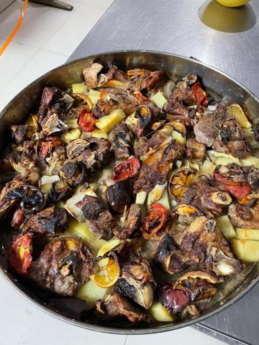 patelnia wypełniona mięsem i warzywami na stole w obiekcie LURA Hotel w mieście Peshkopi