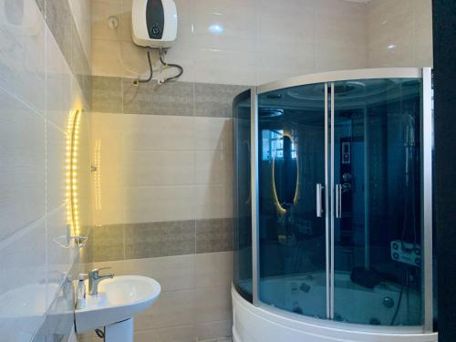 a bathroom with a glass shower and a sink at Urban Haven Lekki in Lekki