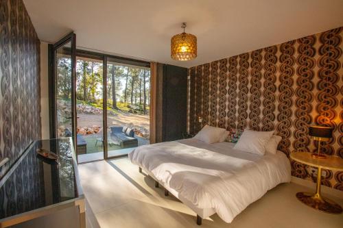 une chambre avec un lit et une grande fenêtre dans l'établissement Villa Horizon 5* Piscine Jacuzzi, à Gémenos