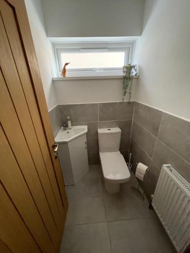 a small bathroom with a toilet and a window at Minster Leas in Sheerness