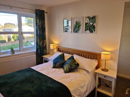 a bedroom with a bed with two pillows and a window at Minster Leas in Sheerness