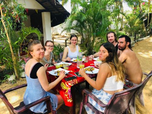 a group of people sitting at a table eating at Star Rest Beach Hotel in Arugam Bay