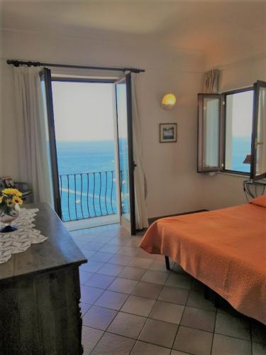 a bedroom with a bed and a view of the ocean at Sorrento Holidays - Casa Marcella in Positano
