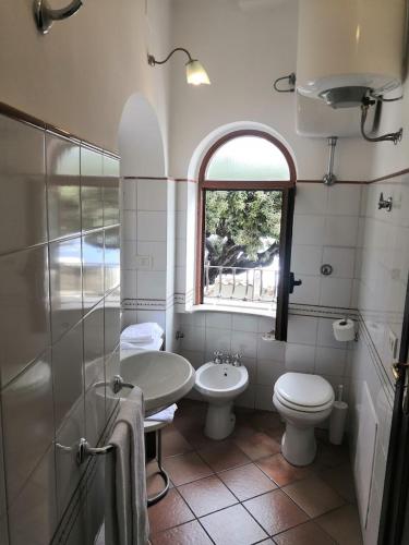 a bathroom with a sink and a toilet and a window at Sorrento Holidays - Casa Marcella in Positano