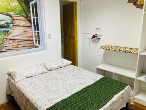 a small bedroom with a bed and a window at Sacavem Flat Hotel Navegantes in Navegantes