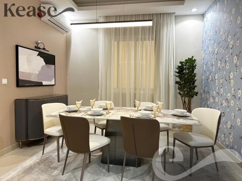 una sala da pranzo con tavolo e sedie bianchi di Kease Al-Mutamarat A-10 Timeless History GX66 a Riyad
