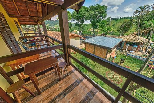 a balcony of a house with a bench and a view at Pousada Pé da Serra in Lindóia