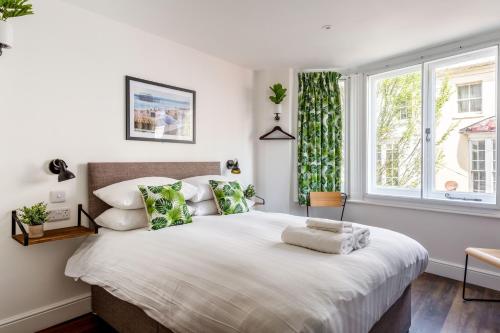 a bedroom with a large bed and a window at Pierview Pad - Central Luxury Apartment on the Beach in Brighton & Hove