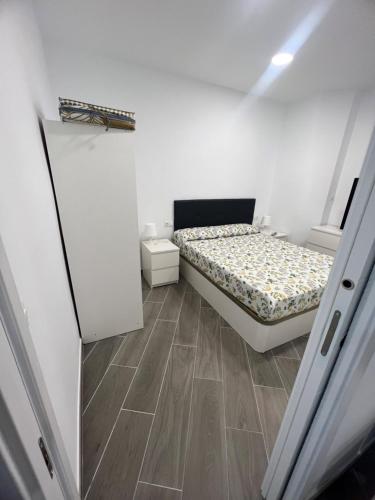 a small bedroom with a bed and a wooden floor at Apartamentos BEACHYDAYS Metropolis D in Torremolinos