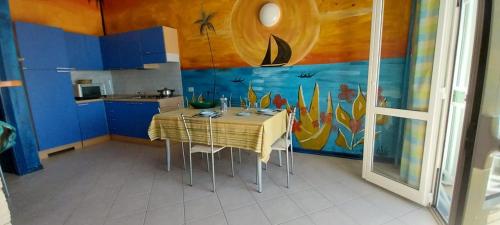 une cuisine avec une table et un tableau mural dans l'établissement Top Residence Beach, à Santa Maria