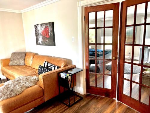 a living room with a couch and a glass door at Budapest - Heritage Tay Basin Water View in Perth