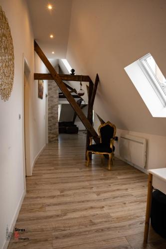 Cette chambre est dotée d'un escalier avec une chaise et une lucarne. dans l'établissement Belles combles alsaciennes au centre de Strasbourg, à Strasbourg