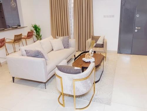 a living room with a white couch and chairs at Harmony villa in Tema