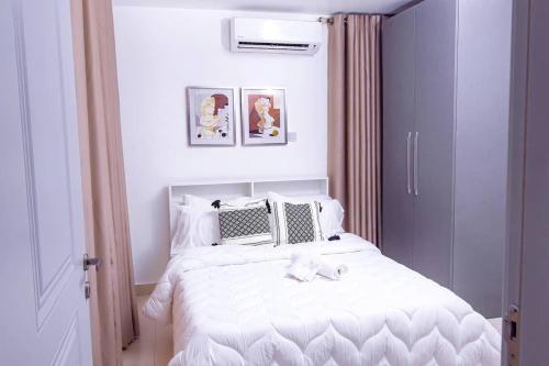 una camera da letto con un letto bianco con un arco sopra di Harmony villa a Tema