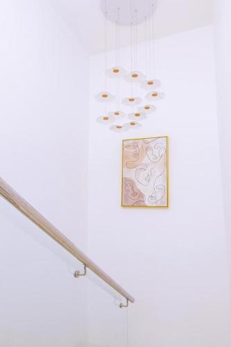 a white wall with a picture and some lights at Harmony villa in Tema