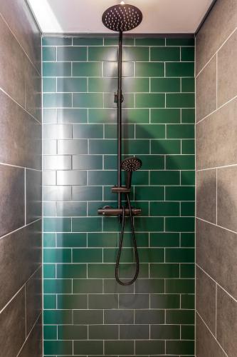 a green tiled shower with a shower head at Pierview Pad - Central Luxury Apartment on the Beach in Brighton & Hove