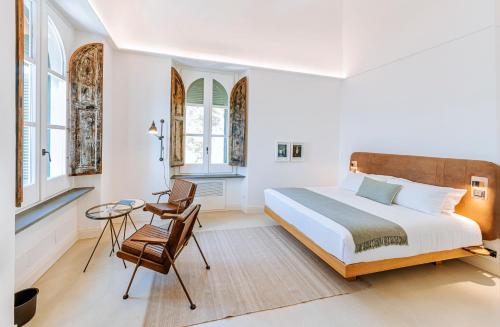1 dormitorio con 1 cama, mesa y sillas en Faro Punta Imperatore en Ischia
