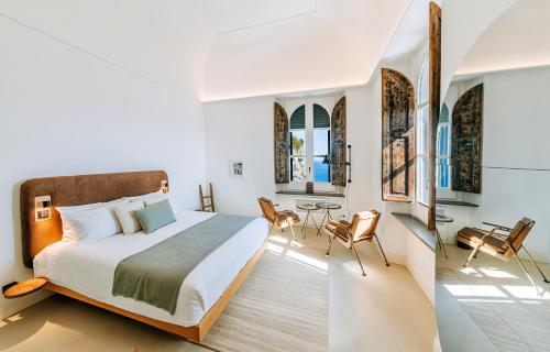 a bedroom with a bed and a table and chairs at Faro Punta Imperatore in Ischia