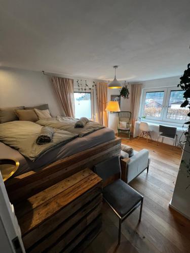 a bedroom with a large bed and a living room at Flat Tom in Schwaighof
