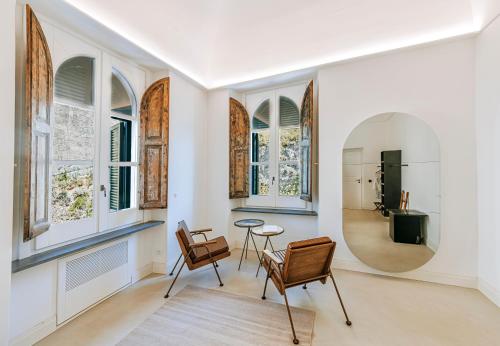 a living room with chairs and a table and windows at Faro Punta Imperatore in Ischia