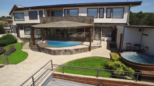 una casa con piscina en el patio trasero en Dein Haus Hotel y Departamentos en Puerto Varas